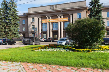 View of the Angarsk city administration building from central square with flower beds and green lawns on a sunny summer day