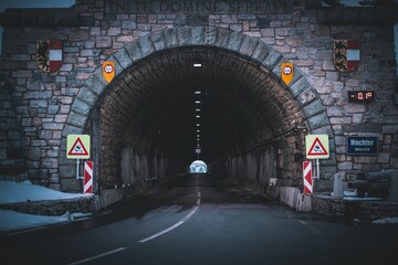 Lange stenen tunnel met waarschuwingsborden voor auto& 39 s in Grossglockener, Oostenrijk