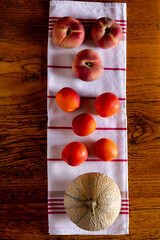 Pêches de vigne, pêches plate, abricot, melon sur une table