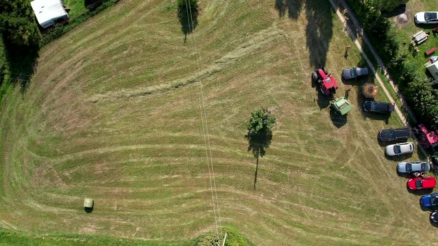 Aerial view flying above lawnmower tractor landscaping grass field in Chmielno, Poland