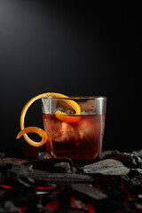 Old-fashioned cocktail with ice and orange peel.
