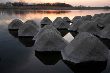 Concrete blocks in the sunset water 