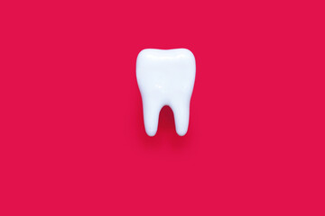 A molar on a pink background in the center of the image. Medical concept of dental health and...
