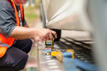 A tow truck with a broken car on a rural road