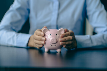 Woman's hand protects a piggy bank, saving money with a pile of coins. Step into a Successful Growing Business Saving Ideas