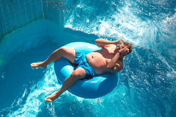 Overweight european tourist aerial lap water park swims in the pool.