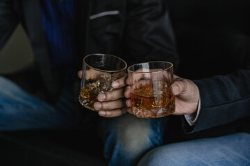 
Close-up of serious businessman holding whiskey glass shows concept of executive privilege. Soft...
