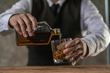 
Close-up of serious businessman holding whiskey glass shows concept of executive privilege. Soft...