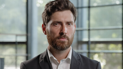 Fototapeta premium Business portrait in office serious calm middle-aged male boss employer adult Caucasian 40s bearded man looking at camera CEO leader trader male salesman manager worker businessman posing indoors