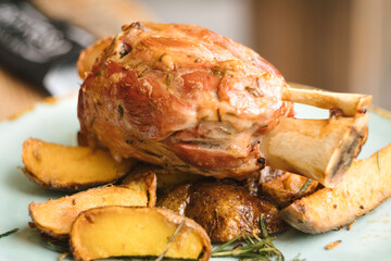 Balkan pork knuckle (svinjska kolenica) stewed under sać pot with potatoes and vegetables
