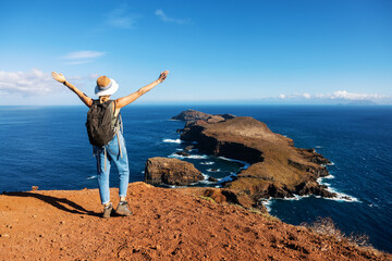 woman enjoying beautiful view to ocean and cliffs on Ponta de Sao Lourenco hiking trail in Madeira island. Portugal