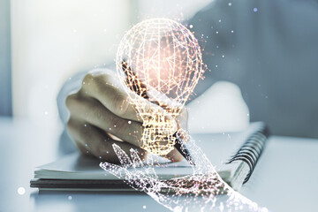 Creative idea concept with light bulb illustration and hand writing in notebook on background....