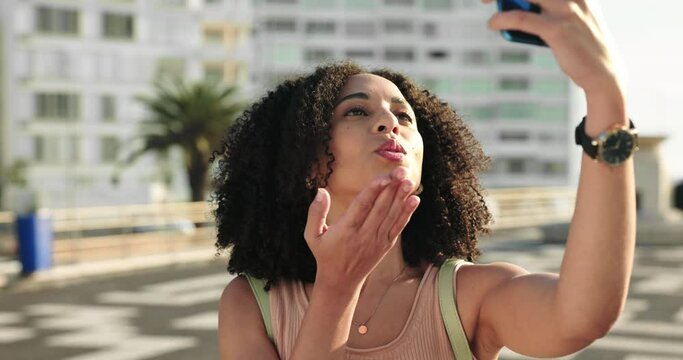 City, phone and video call girl with wave for happy greeting and air kiss on Jamaica holiday. Black woman with mobile for online communication on tropical summer vacation with excited smile.