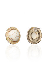 Subject shot of golden round stud earrings adorned with decorative white turquoise. The earrings...