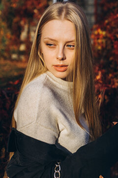 Close up blondie woman outdoor portrait in autumn park. Happy caucasian girl with long natural blondie hair 