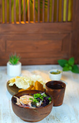 Salmon soup with purple spinach in the wooden bowl