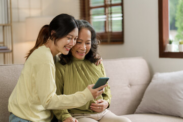 Mature asian mom with daughter on video call to parents, loving mother day concept. - obrazy, fototapety, plakaty