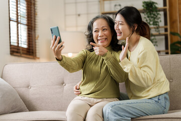 Mature asian mom with daughter on video call to parents, loving mother day concept.