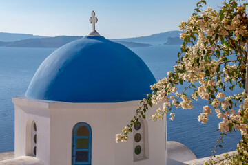 Greek Orthodox chapel with flower blossoms on the island of Santorini