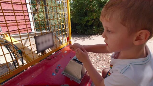 The child controls the excavator slow motion boy digs
