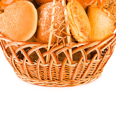 Bread and sweet pastry in a wicker basket isolated on white. Free space for text.