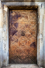 Old metal medieval door with door knocker.