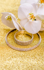 Bracelet and necklace on a gold shiny background
