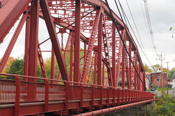 Fototapeta premium The red bridge crosses over the river in this small rural town.
