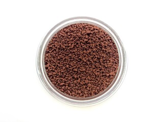 Top view of instant coffee in a glass bottle on white background.
