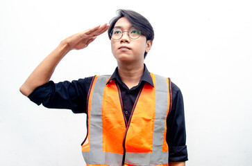 Portrait of a young confident engineer or construction worker in safety yellow helmet and orange vest