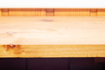 Close-up of a wooden plank at an angle. Wooden table top substrate with shallow depth of field.
