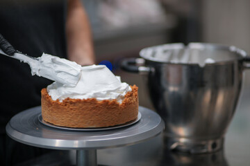 pastry chef designer filling a pie crust with lemon flavour meringue mousse cheese cream with...