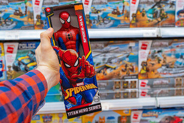 Fototapeta premium Spiderman toy in a toy store. Buyer Choosing Spider-Man Figure. Minsk, Belarus, 2022