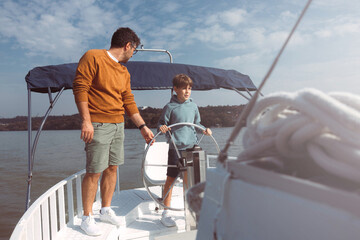 From a young age, the father teaches his son how to steer a ship. It's a nice sunny autumn day...