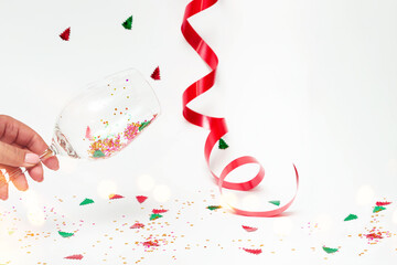 Wine glass in a female hand with festive sparkles on a white background Mockup postcard copy space