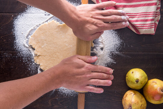 Cropped image of hands rolling dough