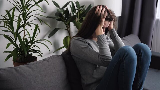 Frustrated depressed young caucasian woman covering face with hands, feeling lonely, crying, suffering from break up with boyfriend or divorce, bad relationship, mental psychological problem concept