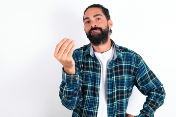 What the hell are you talking about. Shot of frustrated young bearded hispanic man gesturing with raised hand doing Italian gesture, frowning, being displeased and confused with dumb question.