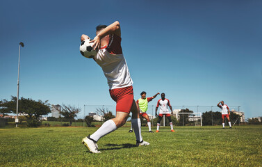 Naklejka premium Football throw and field game of a team in a fitness, exercise and sports match outdoor. Training, soccer workout and athlete teamwork collaboration ready for cardio together in the summer sun