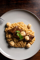 Risotto in beef broth with pieces of tenderloin on top. Rice. Italian food. Meat and rice.