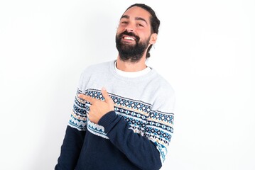 young bearded hispanic man wearing knitted sweater over white background glad cheery demonstrating copy space look novelty