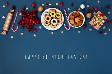 Christmas composition with sweets, candy, gingerbread cookies and gifts on dark blue background, top view.  Saint Nicholas Day, 6 December. - Powered by Adobe