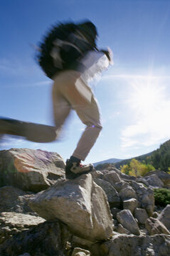 A Hiker Jumps Over Boulders