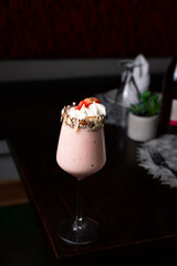 Strawberry milkshake with cream and chopped almonds