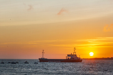 Obraz premium sunset in the sea behind a boat