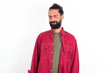 Dismal gloomy rejected Caucasian man with beard wearing red shirt over white background has...