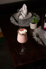 Strawberry milkshake with cream and chopped almonds