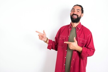 Caucasian man with beard wearing red shirt over white background point at copyspace recommend sales discounts