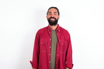 Caucasian man with beard wearing red shirt over white background  with nice beaming smile pleased expression. Positive emotions concept