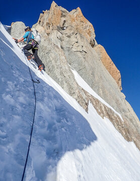 A woman alpinist leads a pitch of steep snow & ice on the Forbes Arete